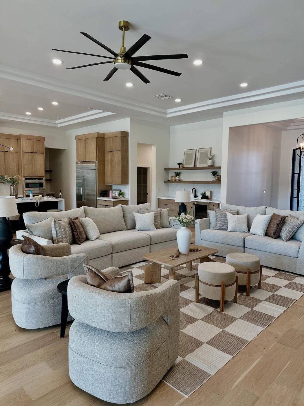 Living room with tray ceiling staged with swivel chairs and a checkerboard rug