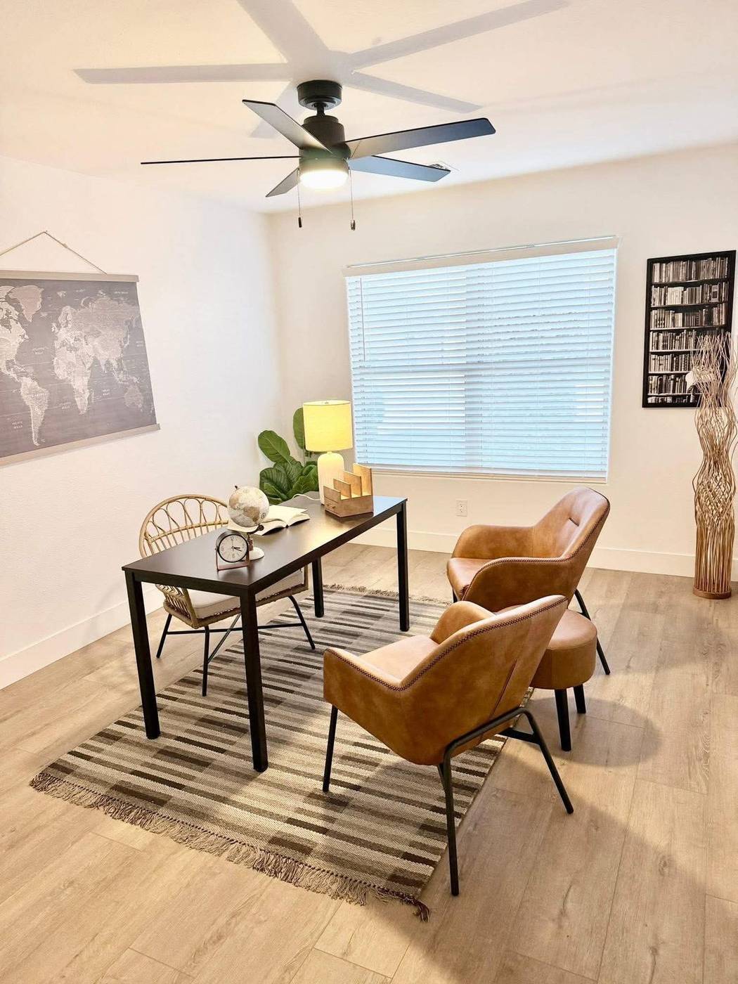 Flex room staged as a home office with a writing desk and two leather chairs in an East Valley listing